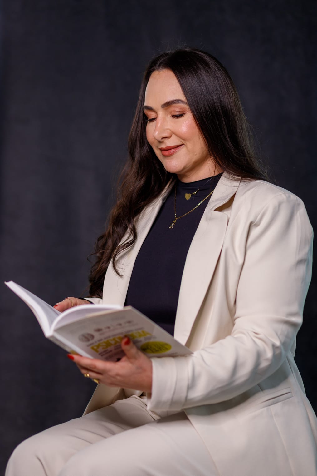 Ariana Braga em foto de estúdio com livro